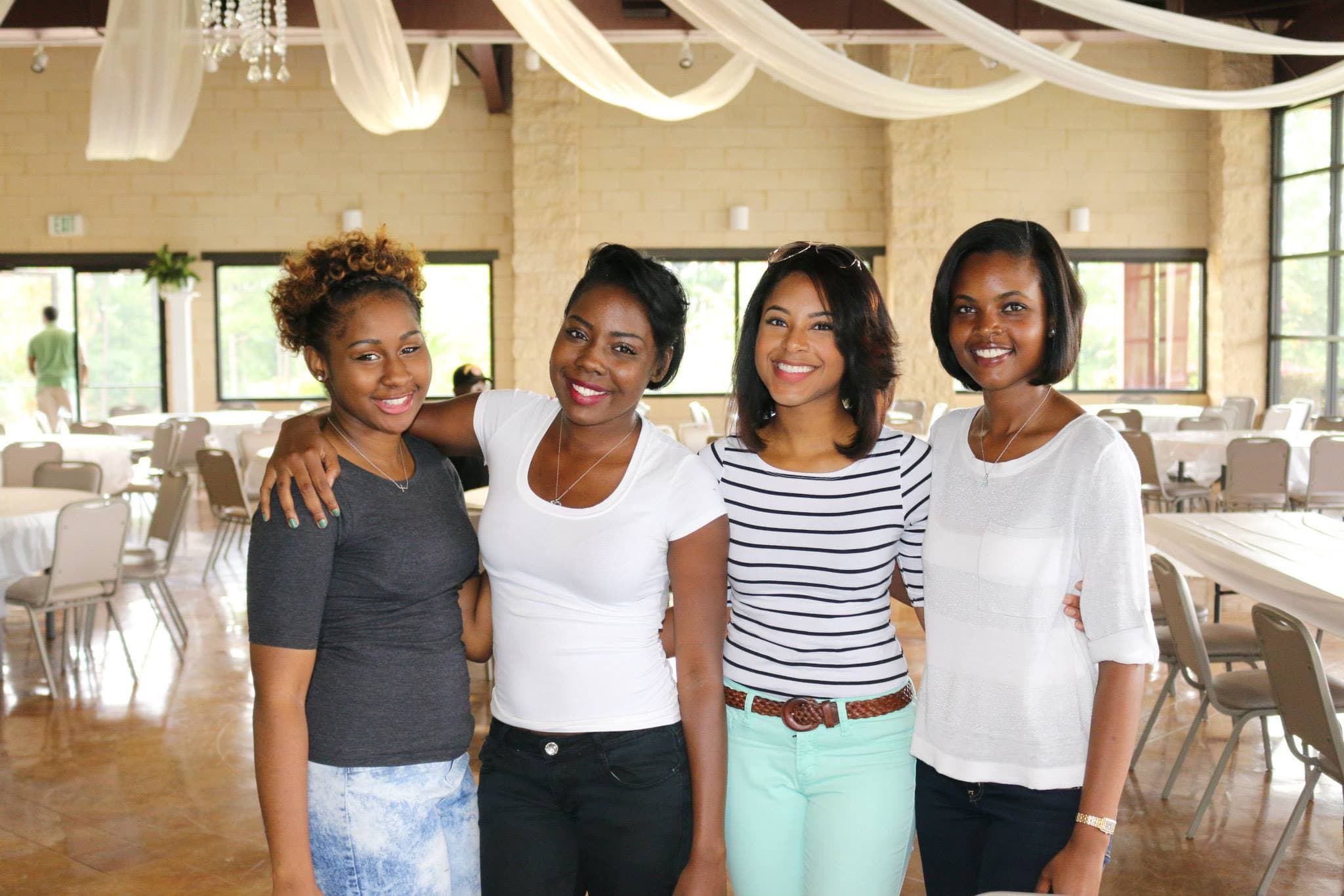 Four women smiling together at a CWC event
